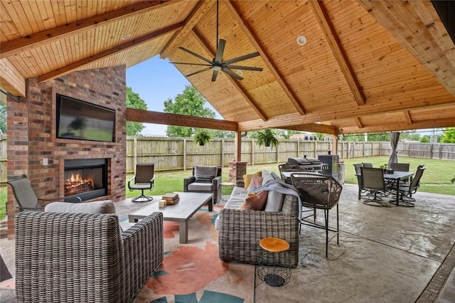 view of patio with an outdoor living space with a fireplace, outdoor dining space, and ceiling fan
