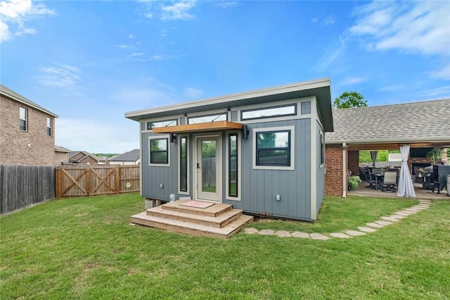 back of property with a gate and an outbuilding