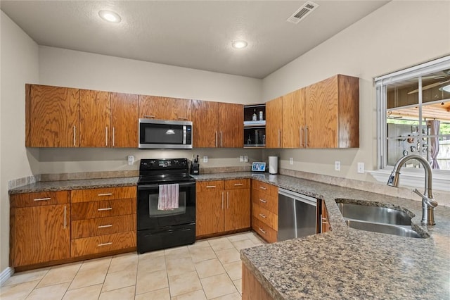 kitchen with appliances with stainless steel finishes, a sink, brown cabinets, open shelves, and light tile patterned floors