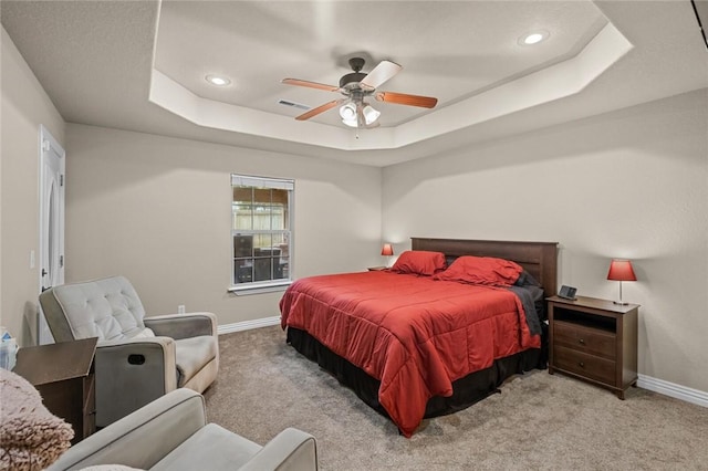 carpeted bedroom featuring a raised ceiling, baseboards, recessed lighting, and a ceiling fan
