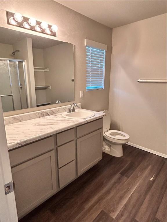 2007 Fennec St, Siloam Springs, AR 72761 - bathroom featuring toilet, wood finished floors, vanity, a shower stall, and baseboards