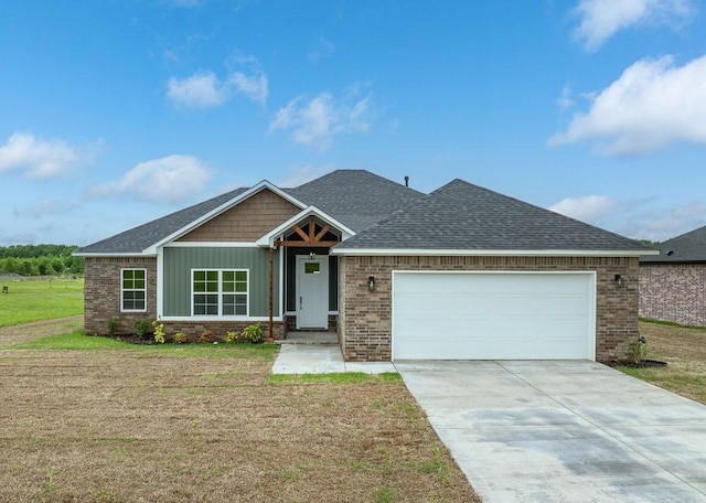 craftsman-style home with a garage, a front lawn, concrete driveway, brick siding, and roof with shingles