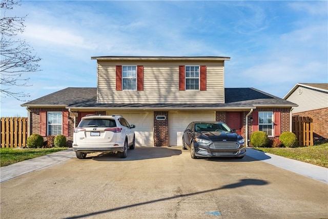 traditional home with driveway, brick siding, fence, an attached garage, and roof with shingles