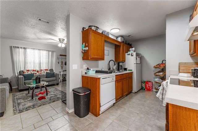 kitchen with white appliances, ceiling fan, visible vents, open floor plan, and light countertops