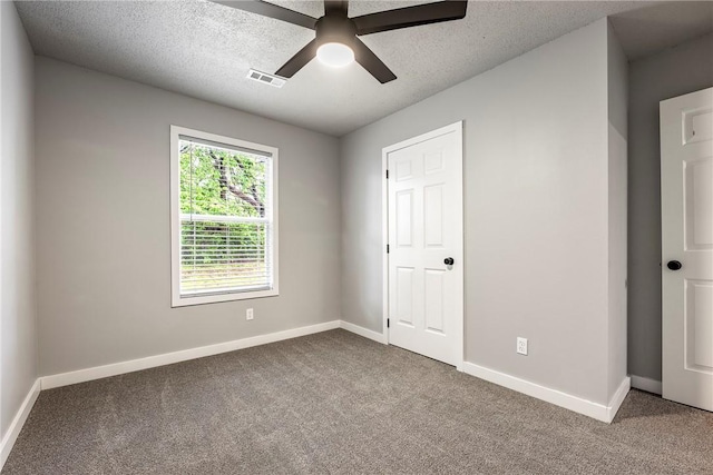 unfurnished bedroom with carpet flooring, a textured ceiling, visible vents, and baseboards