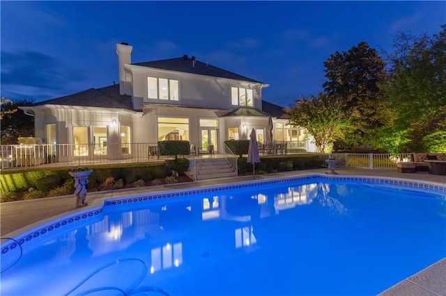 1800 Wheaton Trce, Fort Smith, AR 72908 - back of house at night featuring stucco siding, a chimney, a deck, and a fenced in pool
