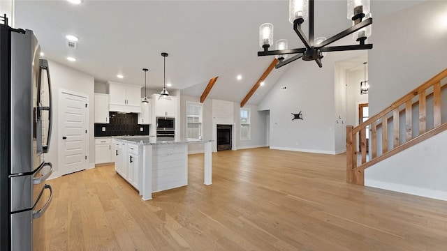 kitchen featuring appliances with stainless steel finishes, white cabinets, open floor plan, light wood-style floors, and recessed lighting
