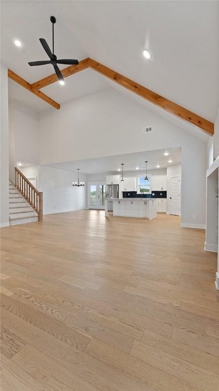 unfurnished living room with beamed ceiling, ceiling fan, high vaulted ceiling, light wood-type flooring, and recessed lighting
