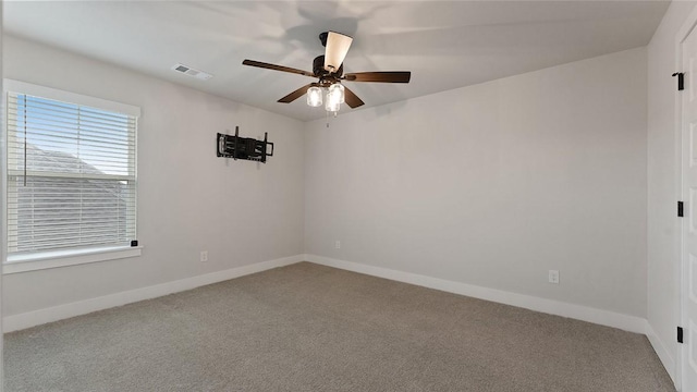 spare room featuring carpet, ceiling fan, and baseboards