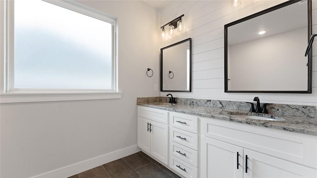 full bathroom with baseboards, tile patterned floors, and double vanity