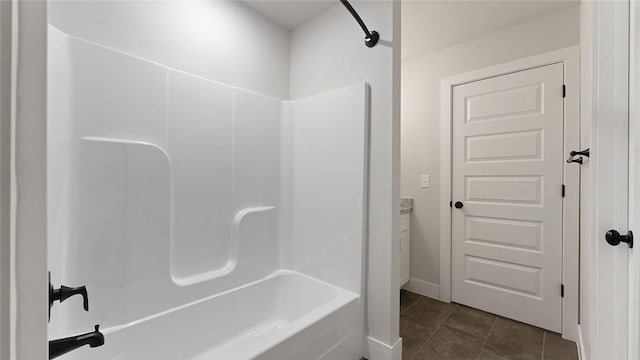 full bath featuring washtub / shower combination, tile patterned flooring, and baseboards