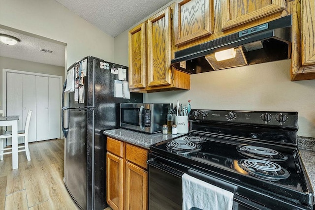 1165 Massey St, Decatur, AR 72722 - kitchen featuring brown cabinets, a textured ceiling, visible vents, black appliances, and under cabinet range hood