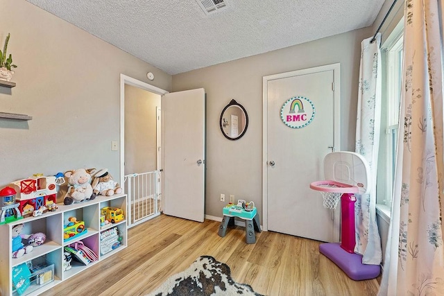 1165 Massey St, Decatur, AR 72722 - rec room with a textured ceiling, visible vents, wood finished floors, and baseboards
