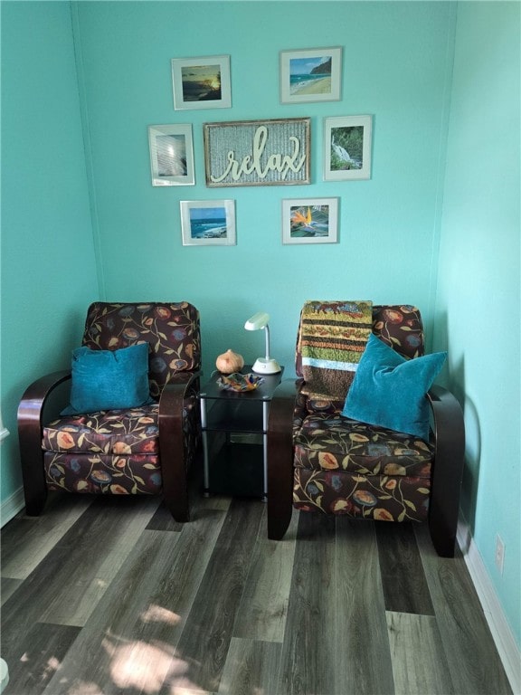 living area with baseboards and wood finished floors