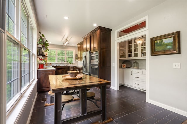 7 Croft Ledge Dr, Bentonville, AR 72712 - kitchen with stainless steel appliances, backsplash, light countertops, recessed lighting, and baseboards