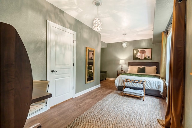 7 Croft Ledge Dr, Bentonville, AR 72712 - bedroom with wood finished floors, baseboards, and a textured wall