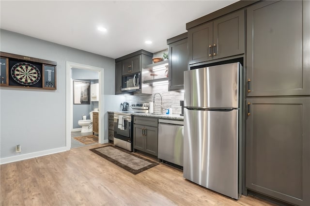 7 Croft Ledge Dr, Bentonville, AR 72712 - kitchen with appliances with stainless steel finishes, open shelves, baseboards, decorative backsplash, and light wood finished floors