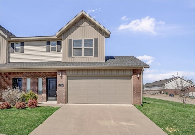 view of front of house with board and batten siding, brick siding, an attached garage, concrete driveway, and a front yard