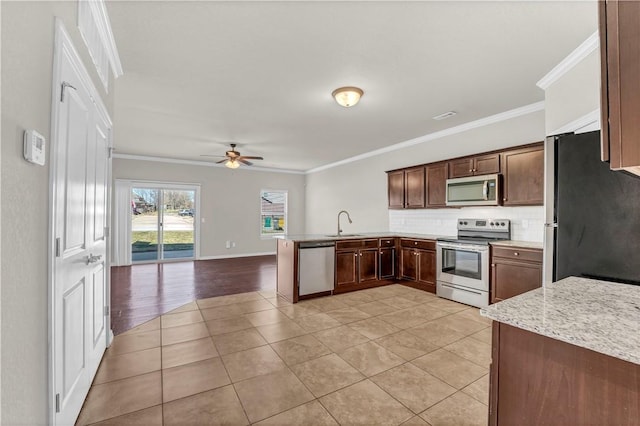 kitchen with a peninsula, crown molding, stainless steel appliances, and light tile patterned flooring