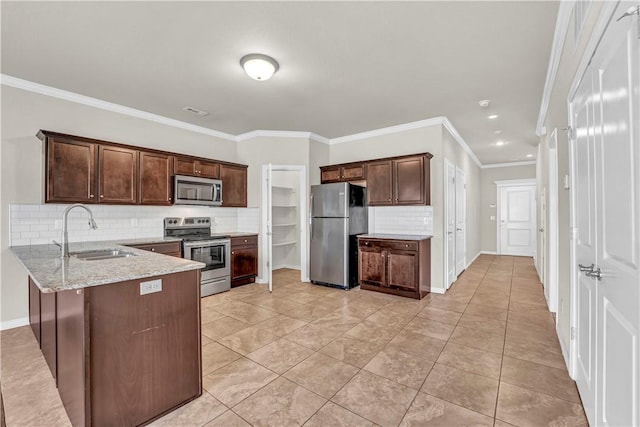 kitchen featuring a sink, dark brown cabinetry, tasteful backsplash, and appliances with stainless steel finishes