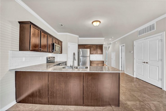 kitchen with a sink, stainless steel appliances, visible vents, backsplash, and light stone counters