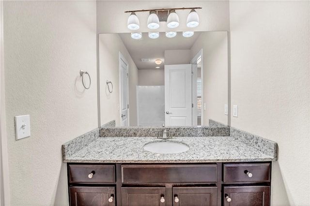 bathroom with vanity and a textured wall