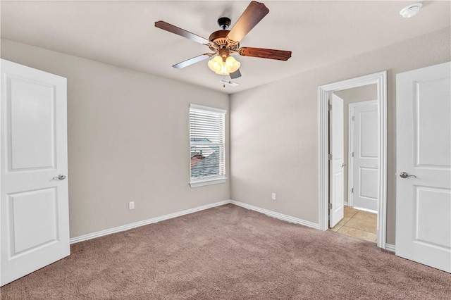 unfurnished bedroom featuring baseboards, light carpet, and ceiling fan