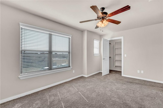 unfurnished bedroom featuring carpet flooring, baseboards, and a ceiling fan