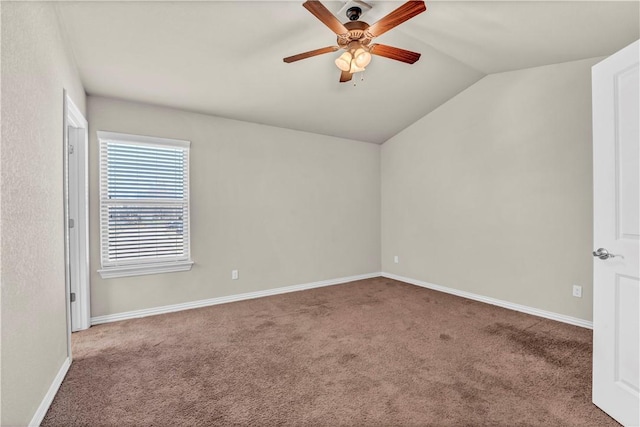 carpeted empty room with lofted ceiling, baseboards, and a ceiling fan