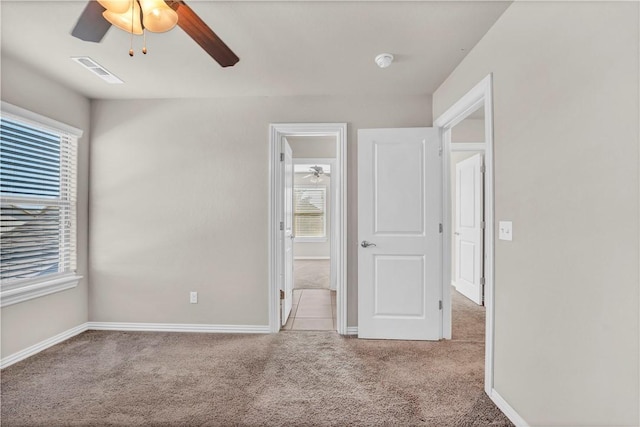 unfurnished bedroom featuring baseboards, a ceiling fan, visible vents, and carpet floors