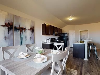 dining room with lofted ceiling and dark wood finished floors