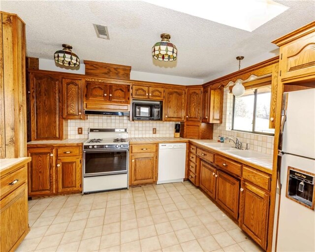 315 N Letitia Ave, Fayetteville, AR 72701 - kitchen with white appliances, custom range hood, decorative backsplash, a textured ceiling, and brown cabinetry