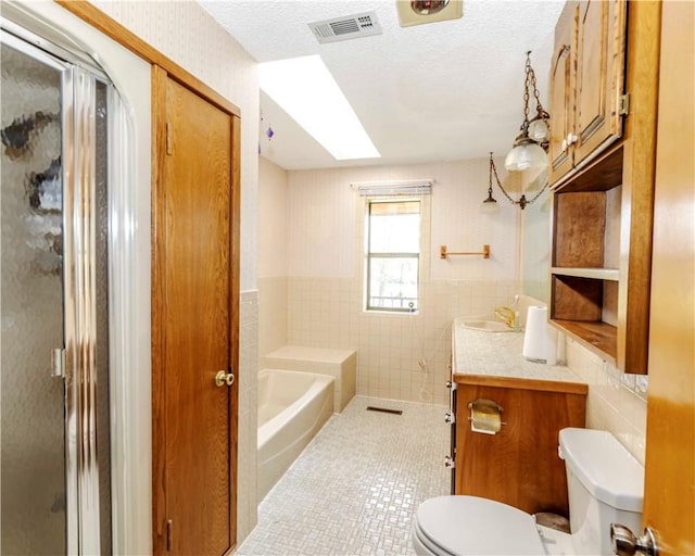 315 N Letitia Ave, Fayetteville, AR 72701 - bathroom with tile walls, a shower stall, vanity, tile patterned floors, and a skylight