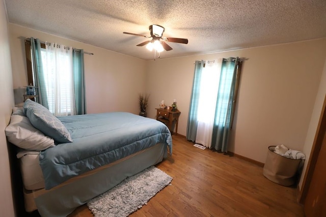 602 Centennial Ave, West Fork, AR 72774 - bedroom with light wood-style flooring, a textured ceiling, and a ceiling fan