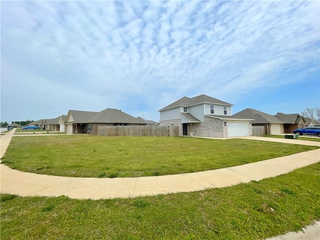 view of side of property with brick siding, driveway, fence, and a lawn