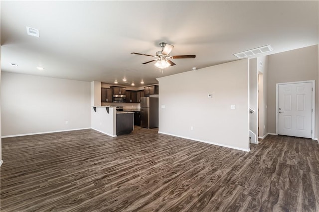 unfurnished living room with a ceiling fan, baseboards, dark wood finished floors, and visible vents