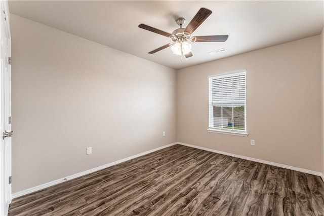unfurnished room featuring baseboards, a ceiling fan, visible vents, and dark wood finished floors