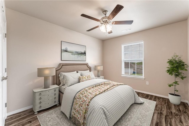 bedroom with ceiling fan, baseboards, visible vents, and wood finished floors
