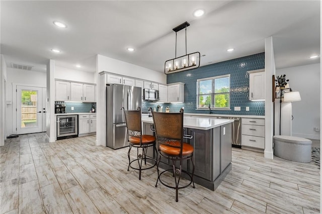 142 N Sheep Dog Ave, Farmington, AR 72730 - kitchen with stainless steel appliances, visible vents, light countertops, decorative backsplash, and wine cooler