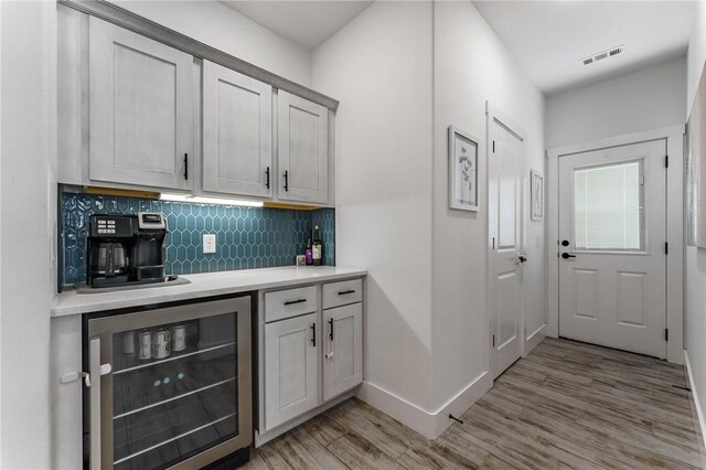 142 N Sheep Dog Ave, Farmington, AR 72730 - bar featuring wine cooler, visible vents, light wood-style flooring, backsplash, and baseboards