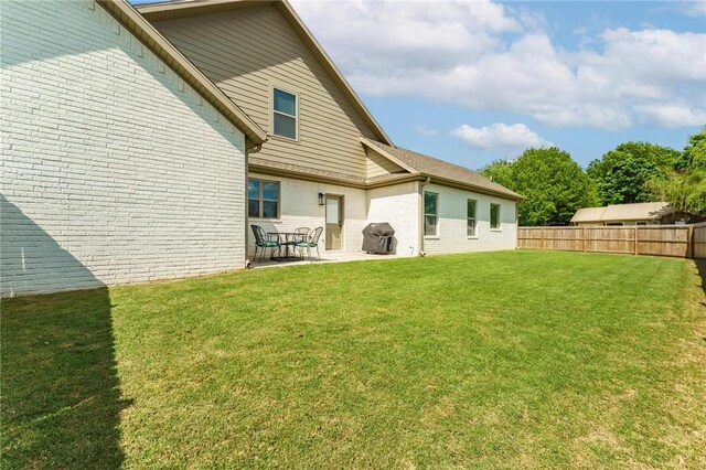 142 N Sheep Dog Ave, Farmington, AR 72730 - back of house featuring brick siding, fence, a lawn, and a patio area