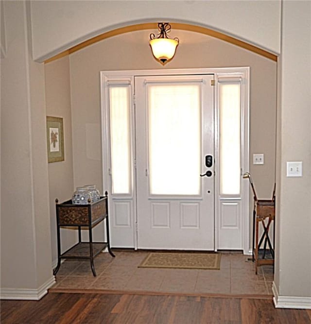 42 Sable Dr, Bella Vista, AR 72715 - entrance foyer featuring arched walkways, baseboards, and dark wood-type flooring