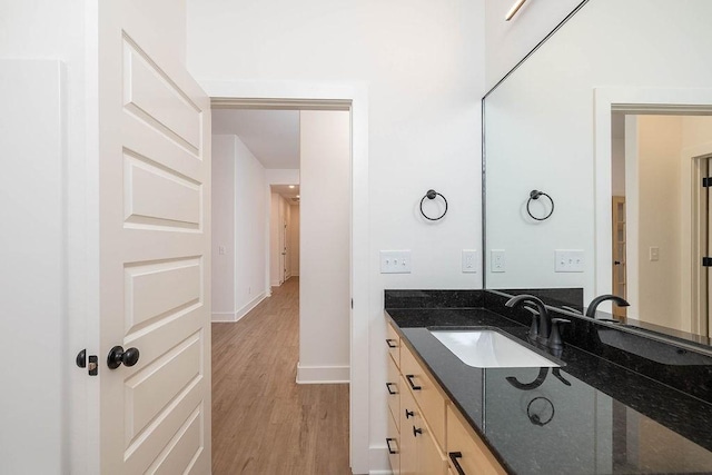 bathroom featuring vanity, baseboards, and wood finished floors