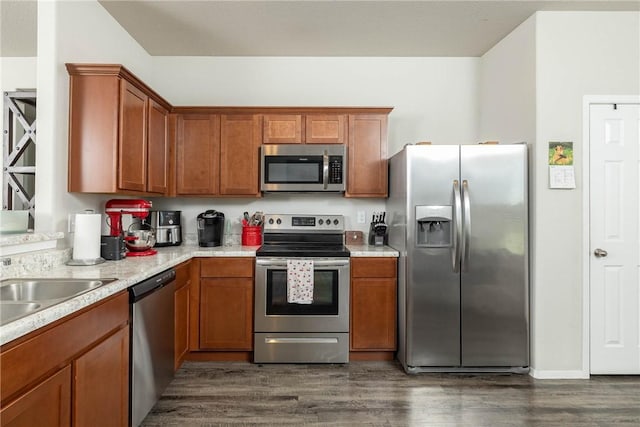 2300 Double Bogey Ln, Farmington, AR 72730 - kitchen with brown cabinetry, light countertops, dark wood-style floors, and appliances with stainless steel finishes
