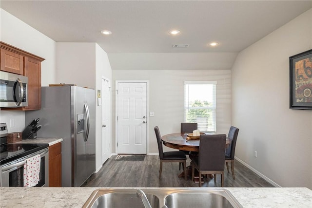 2300 Double Bogey Ln, Farmington, AR 72730 - kitchen with brown cabinetry, stainless steel appliances, visible vents, and dark wood-type flooring