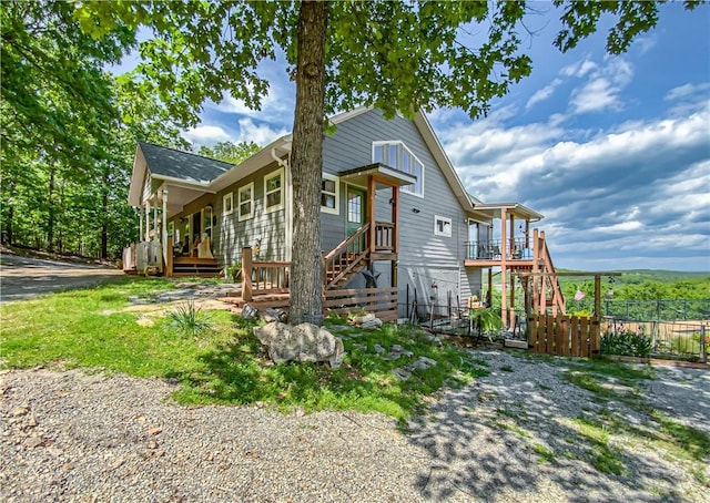view of front of property with fence, stairs, and a deck