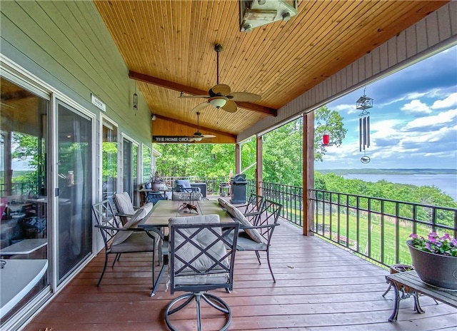 deck featuring outdoor dining area, a water view, and a ceiling fan