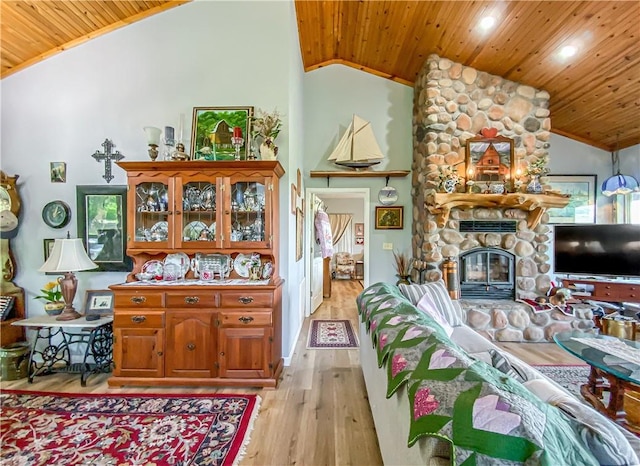 living area featuring a fireplace, wooden ceiling, and vaulted ceiling