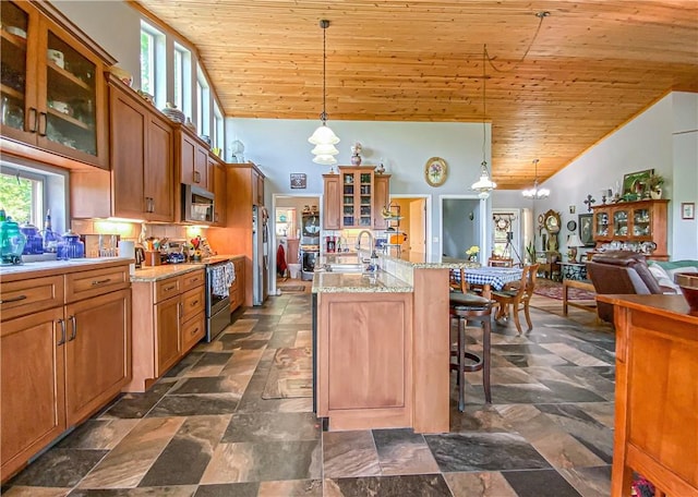 kitchen with a sink, stainless steel appliances, brown cabinets, a breakfast bar, and wood ceiling