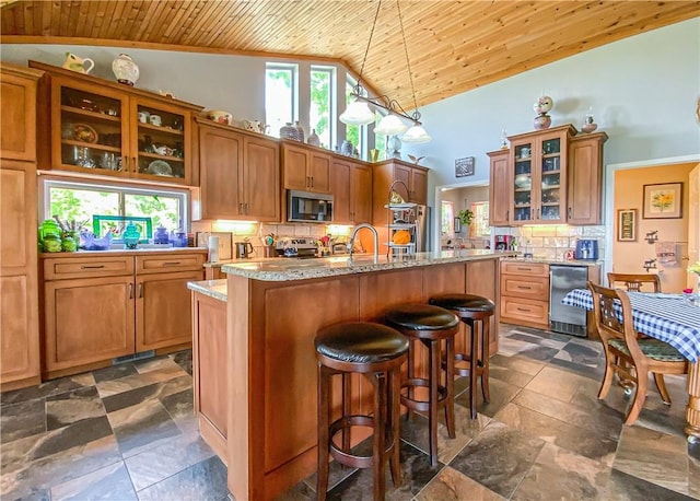 kitchen featuring brown cabinetry, tasteful backsplash, wood ceiling, and appliances with stainless steel finishes
